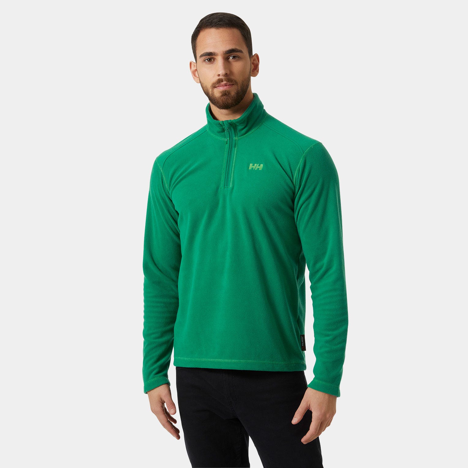 Green 1/2 zip fleece pullover by Helly Hansen featuring a high collar, soft material, and a subtle logo on the chest, paired with black pants.