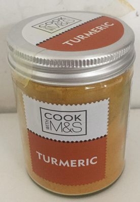 Glass jar filled with bright yellow turmeric powder, featuring a silver metal lid and a label that reads "COOK WITH M&S TURMERIC" in orange and white.