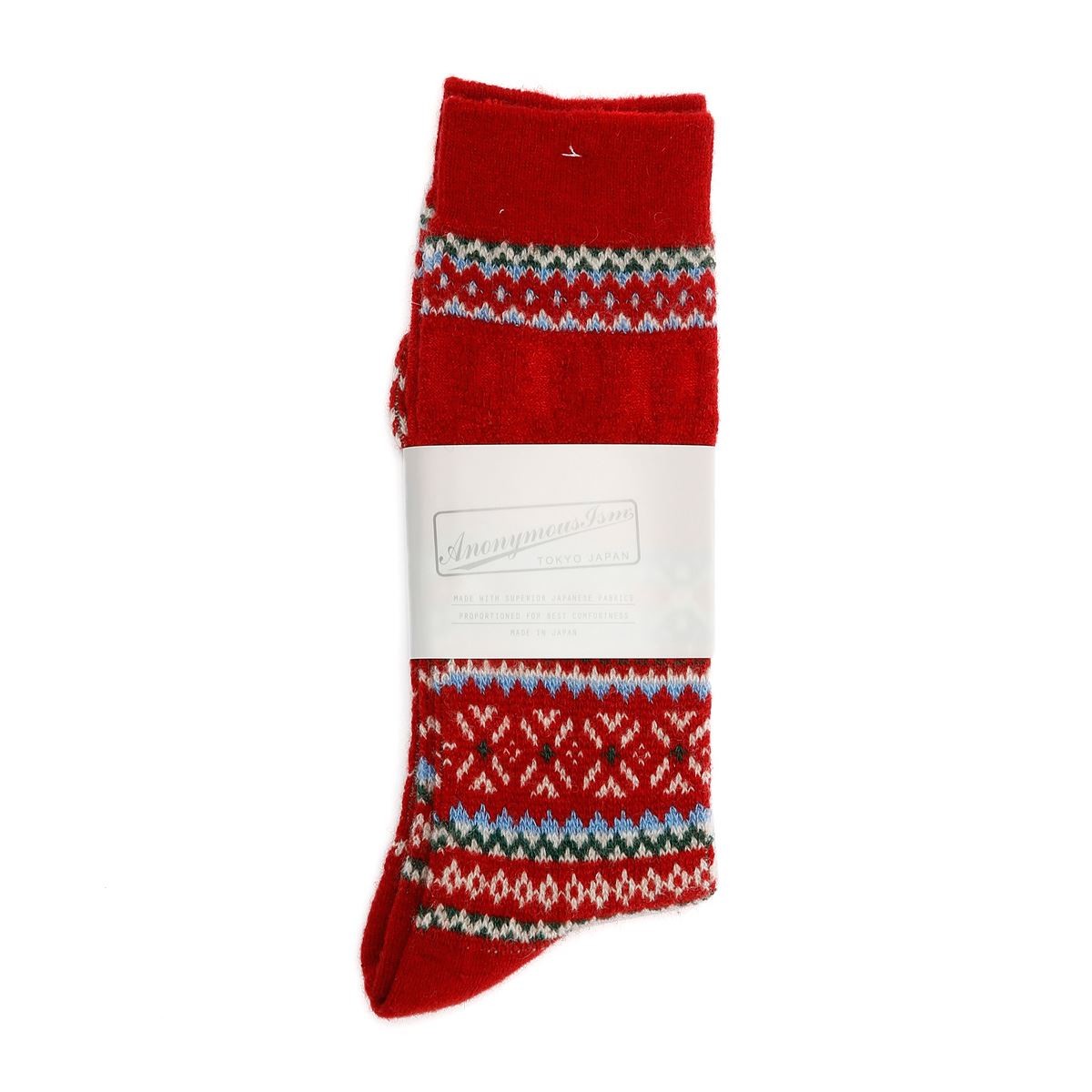 Red crew socks featuring a festive snowflake and geometric pattern in white, green, and blue, made from soft material, with a branded paper band around the middle.