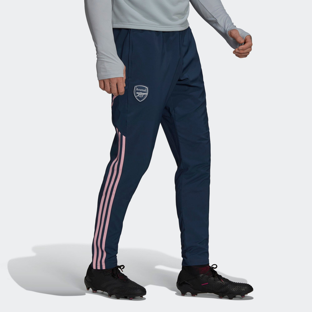 Blue Adidas Arsenal presentation tracksuit bottoms featuring pink side stripes, a comfortable fit, and the Arsenal logo on the left thigh.
