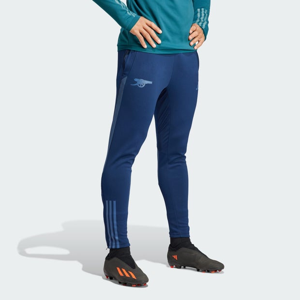 Navy training pants by Arsenal, featuring a subtle logo on the thigh, slim fit, and three white Adidas stripes along the sides.