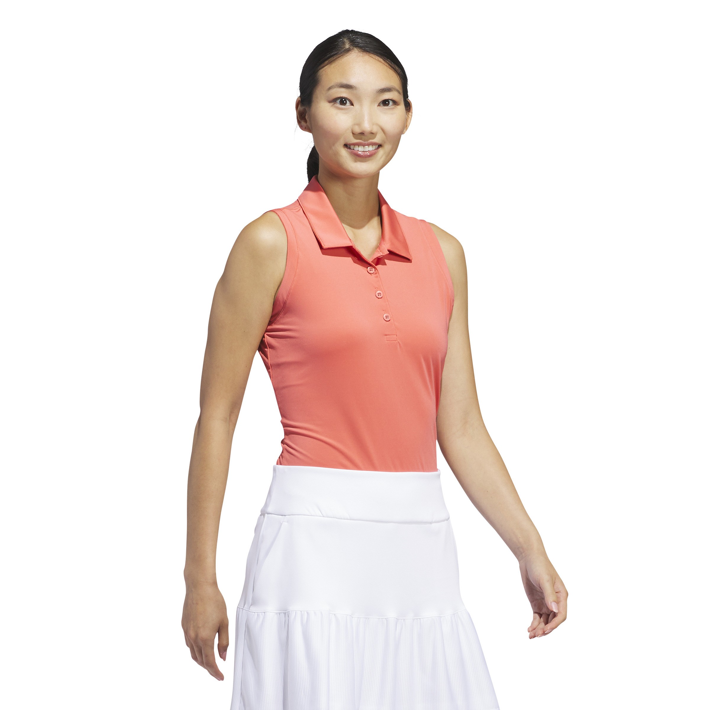 Sleeveless coral polo shirt with a buttoned placket and a classic collar, paired with a white skirt, designed for women's golf by Adidas Ultimate365.