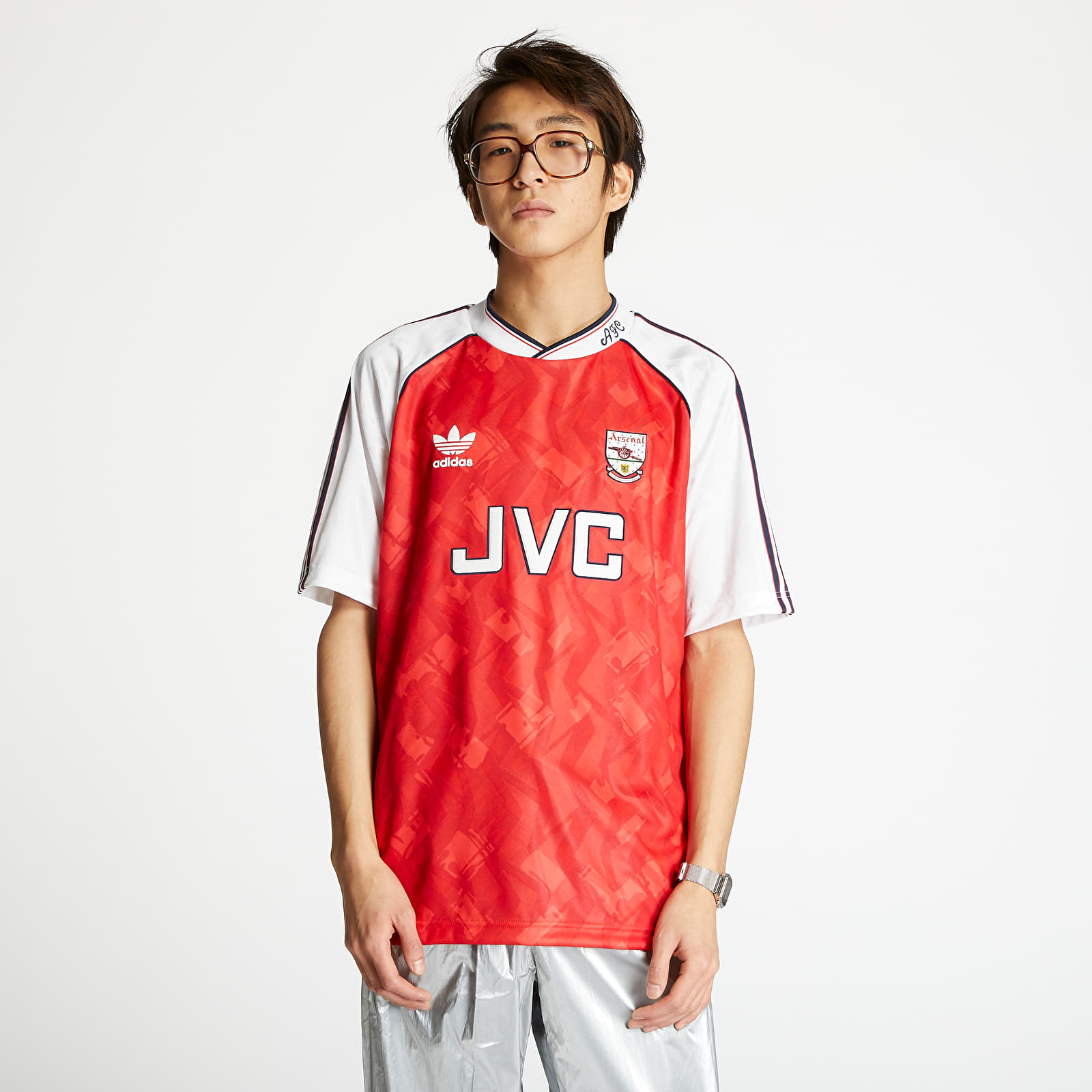 Red and white Adidas Arsenal jersey featuring a geometric pattern, JVC logo on the front, and classic three-stripe detailing on the shoulders.