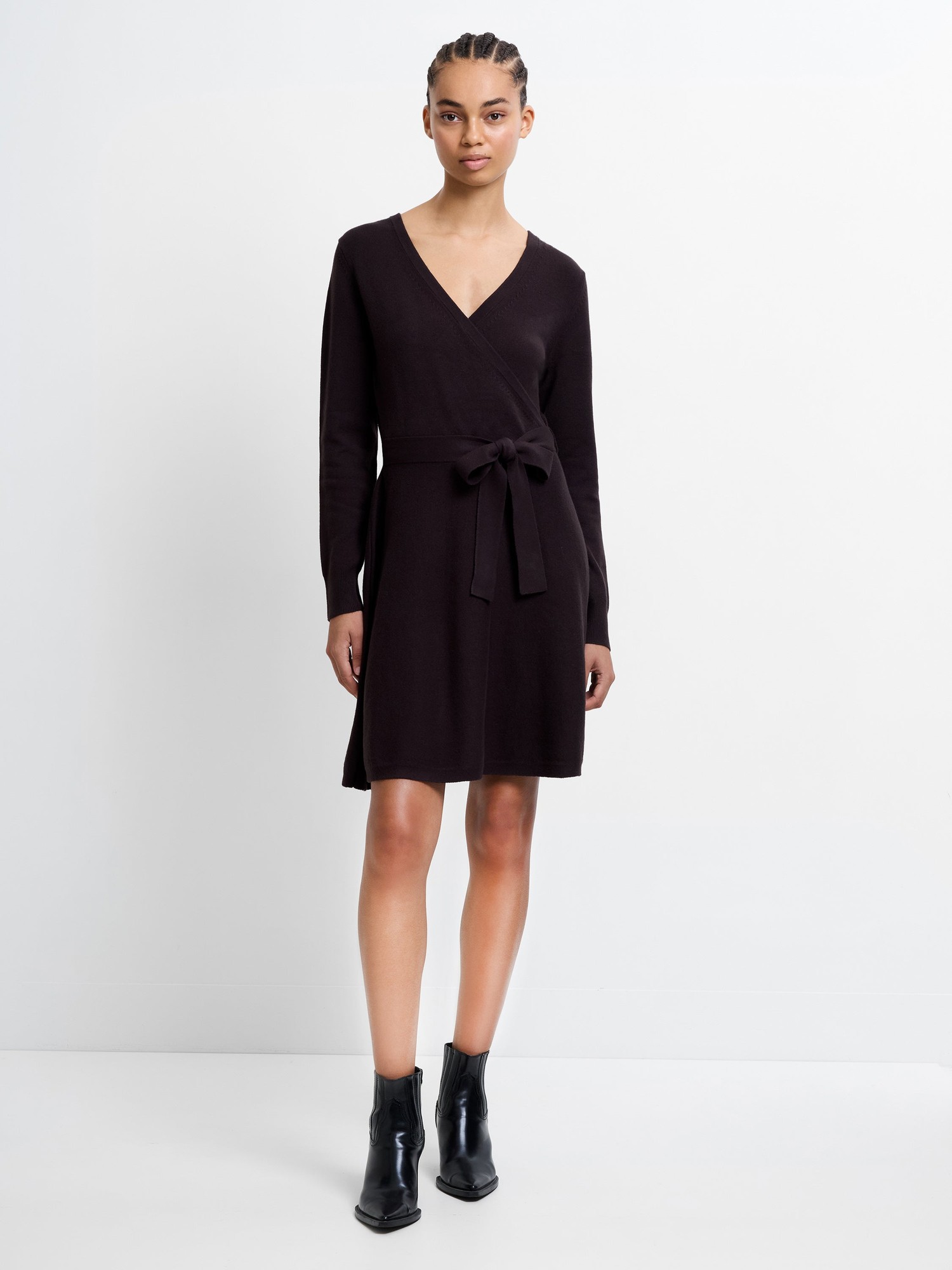 Dark purple Babysoft Wrap Mini Dress by French Connection, featuring a deep V-neck, long sleeves, a tie waist, and a soft knit material, paired with black ankle boots.