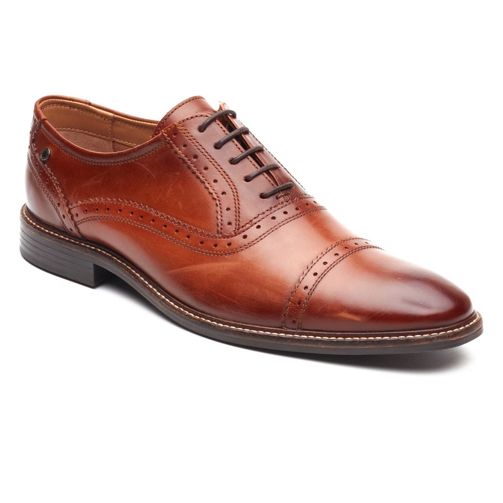 Burnt tan leather Oxford shoes featuring a sleek design, decorative perforations, and a smooth cap toe, complemented by a sturdy black sole and laces.