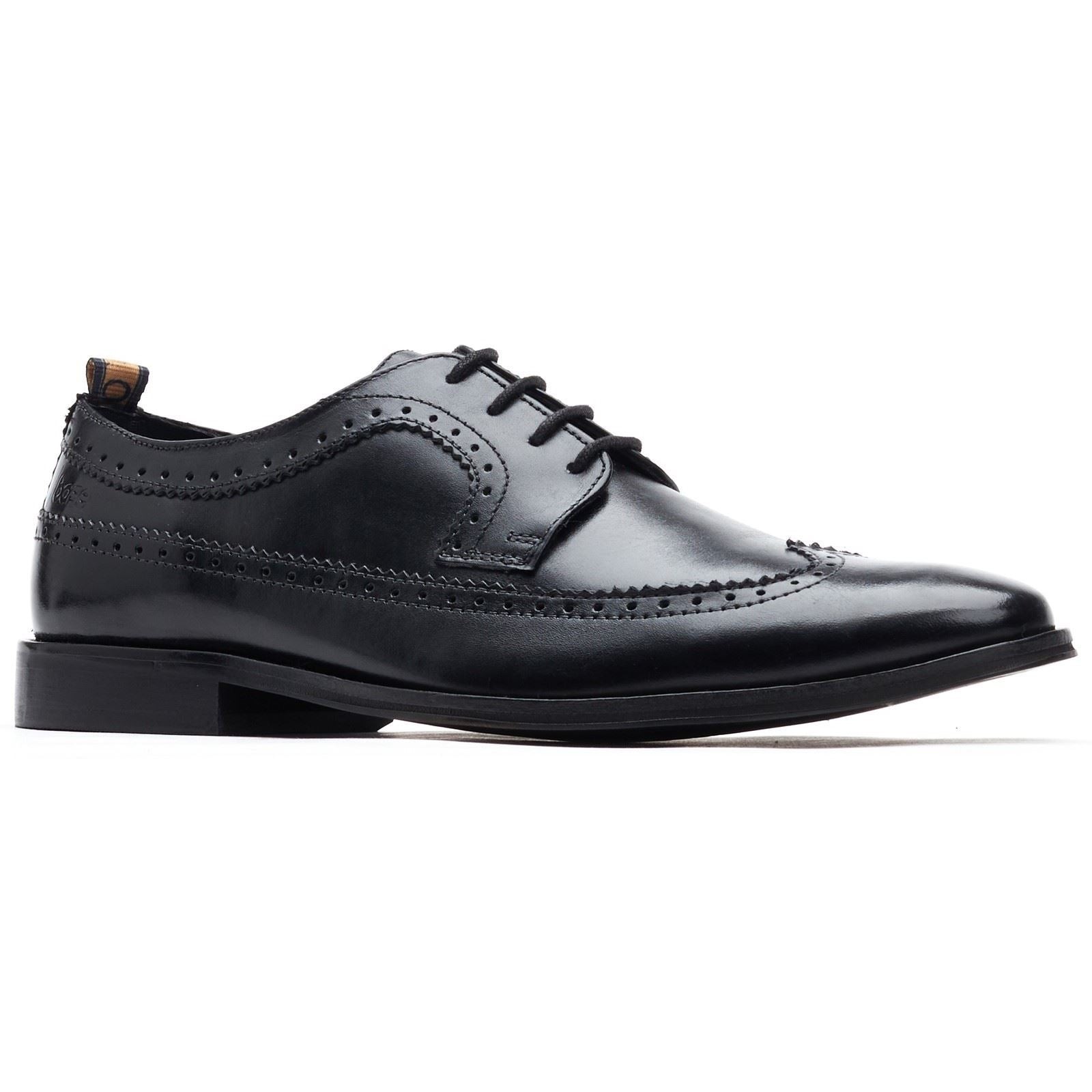 Black leather brogues featuring intricate perforated detailing, a sleek silhouette, and a smooth finish, designed for men's formal wear by Base London.
