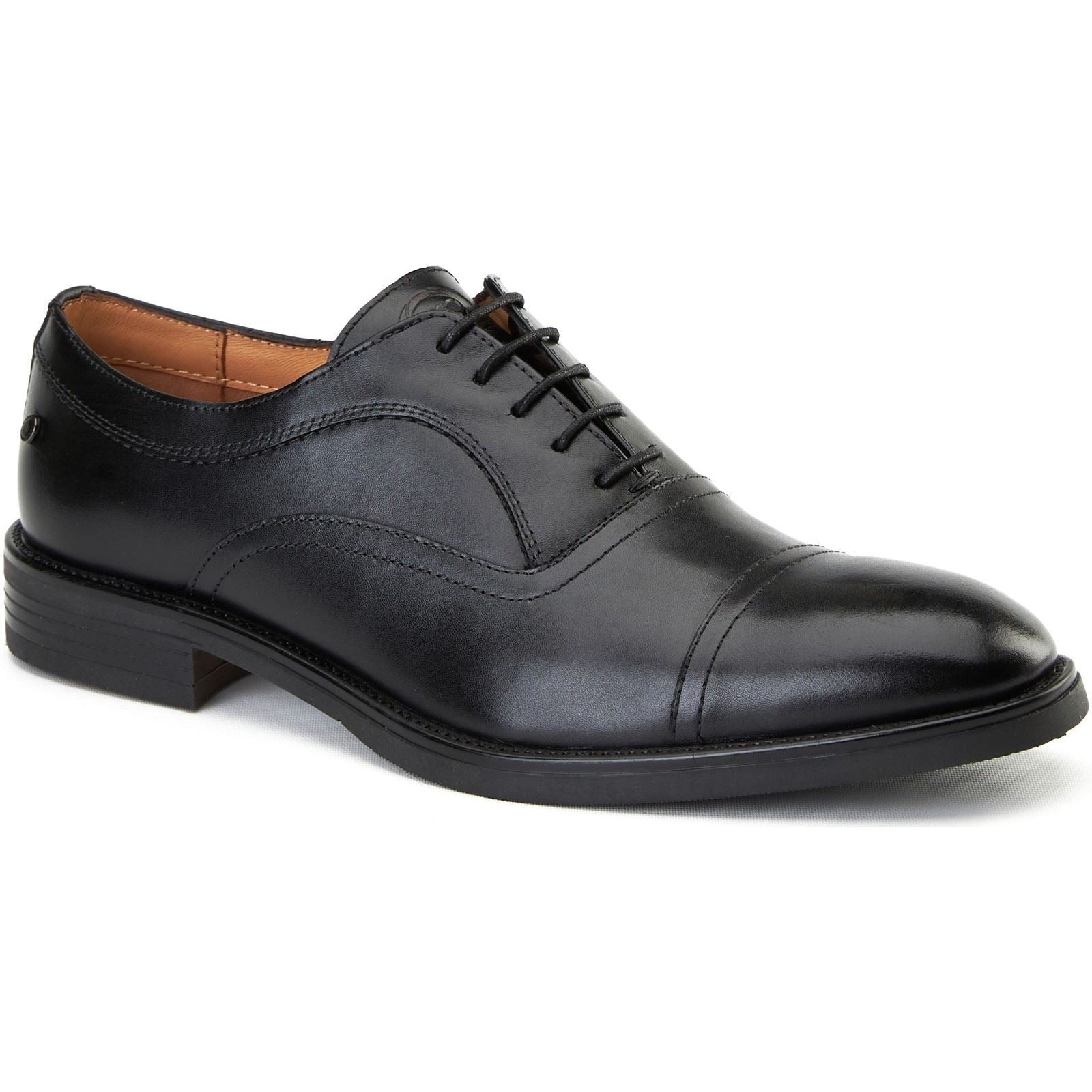 Black leather Oxford shoes featuring a smooth finish, cap toe design, and traditional lace-up closure, with a sleek silhouette and a low stacked heel.