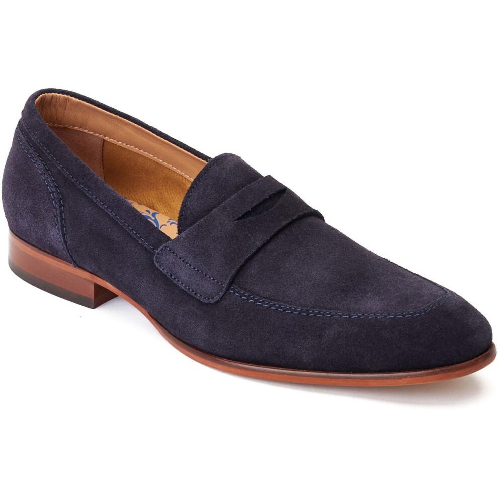 Navy suede penny loafer with a stitched vamp and a low stacked heel, featuring a smooth leather lining and a classic silhouette, available in size 7.