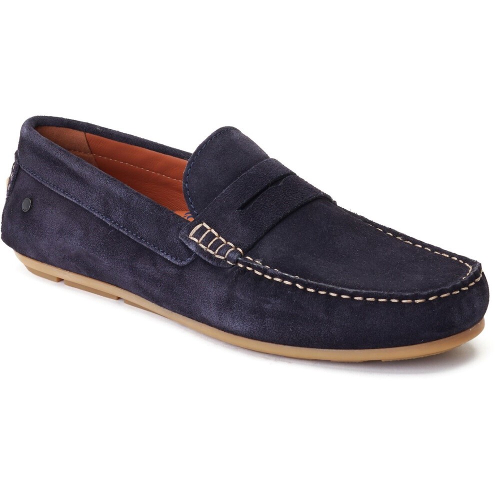 Navy blue suede loafers with a stitched moccasin design, featuring a slip-on style and a tan rubber sole for comfort.