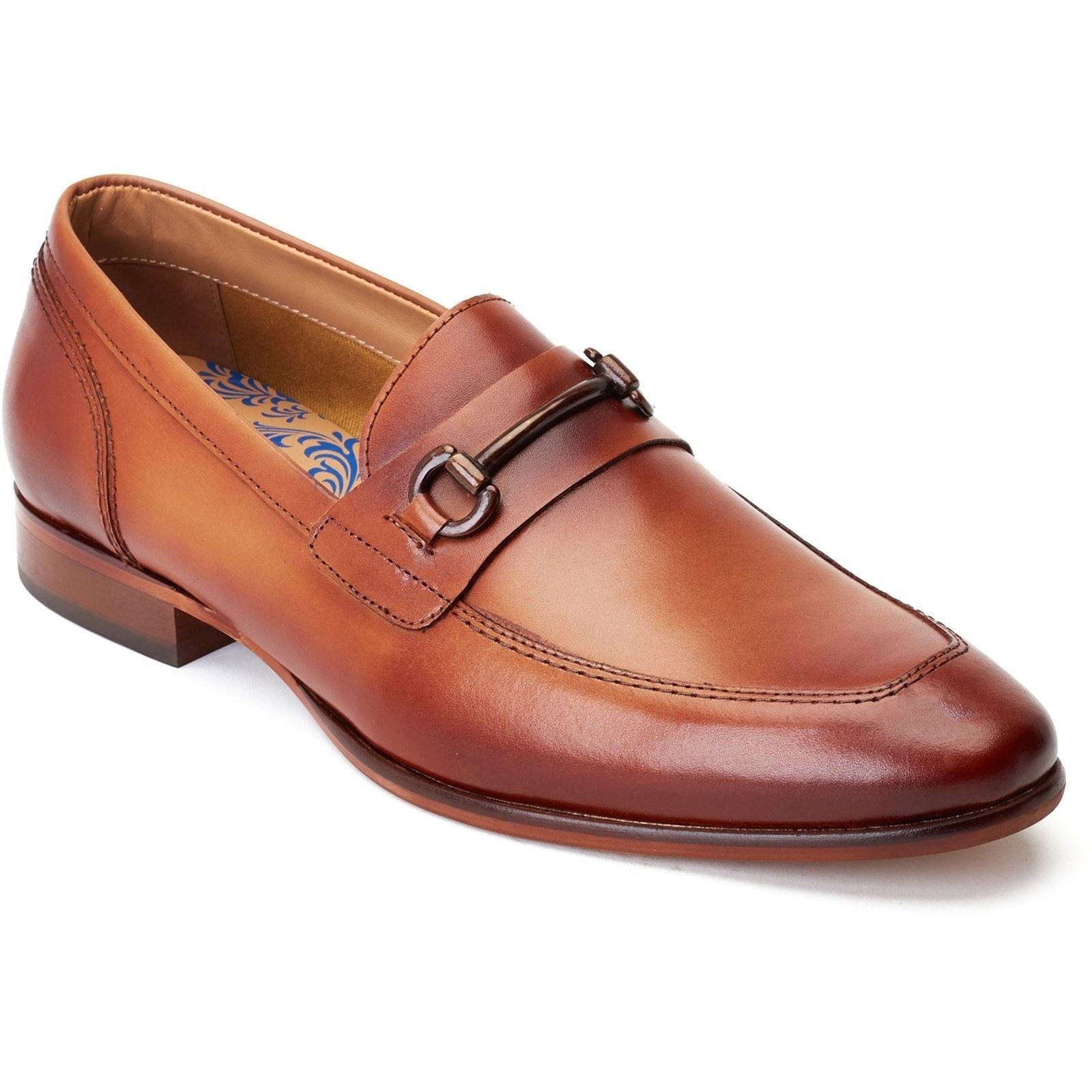 Tan leather loafer featuring a sleek design, a decorative buckle across the vamp, and a low stacked heel, available in size 7.