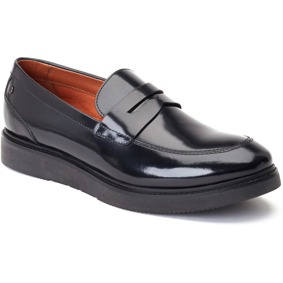 Black leather penny loafer with a glossy finish, featuring a stitched toe cap, a raised front strap, and a thick black rubber sole, available in size 7.