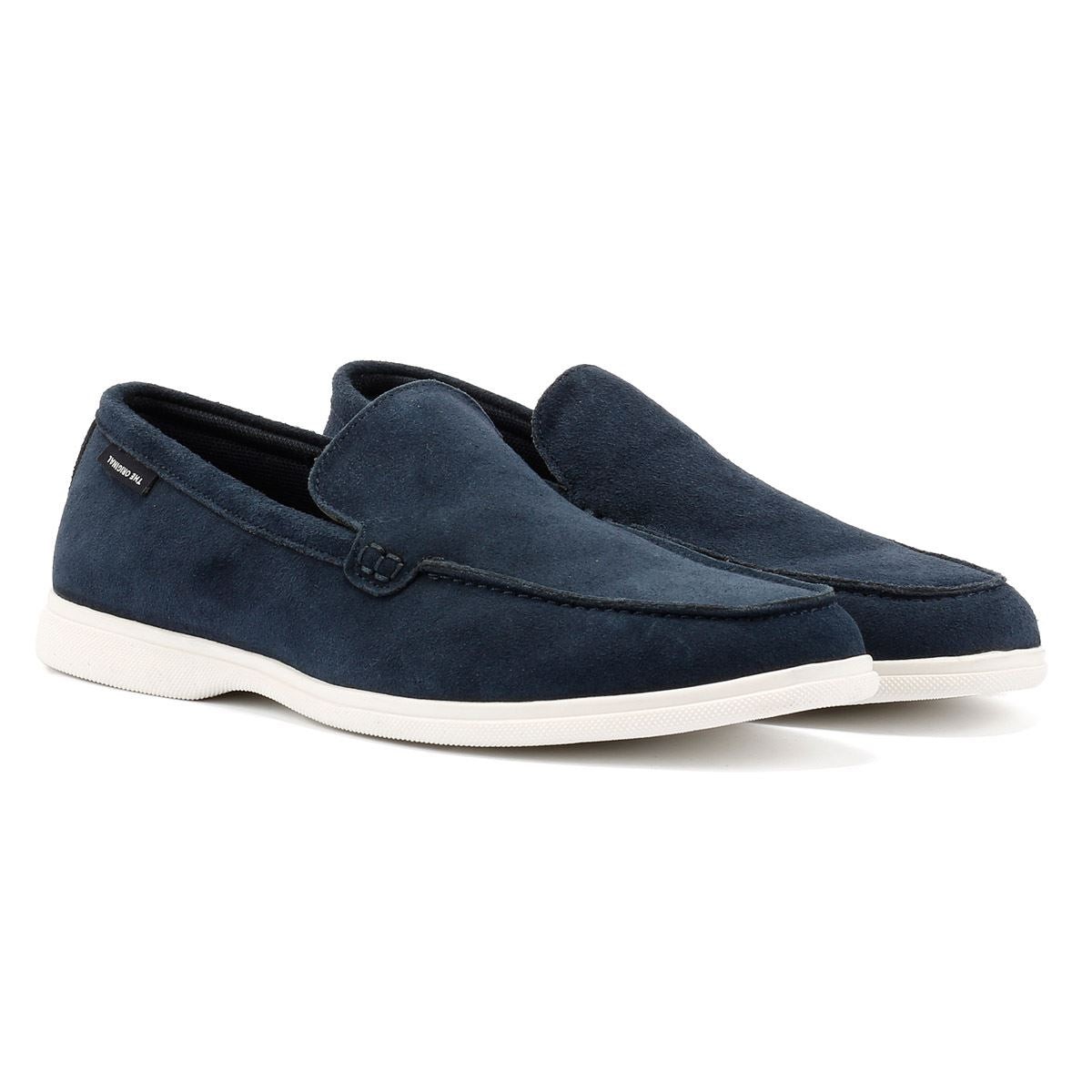 Blue suede slip-on shoes with a white rubber sole, featuring a sleek design and a subtle logo tag on the side, in size 7.