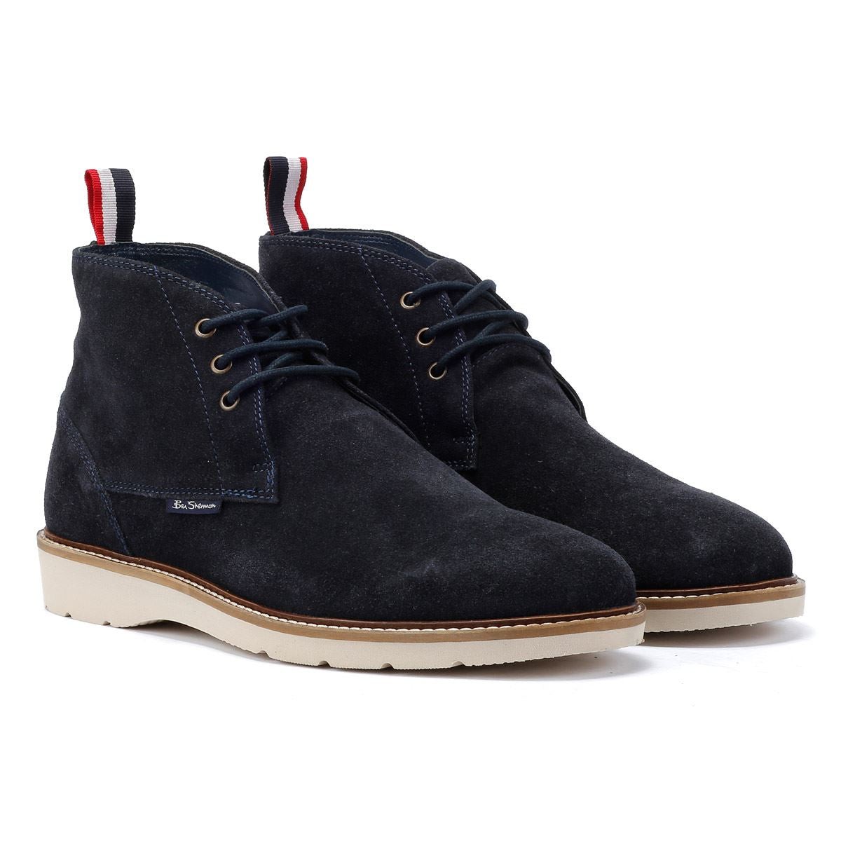 Navy suede men's boots featuring a lace-up design, contrasting beige sole, and a red and navy pull tab at the back.