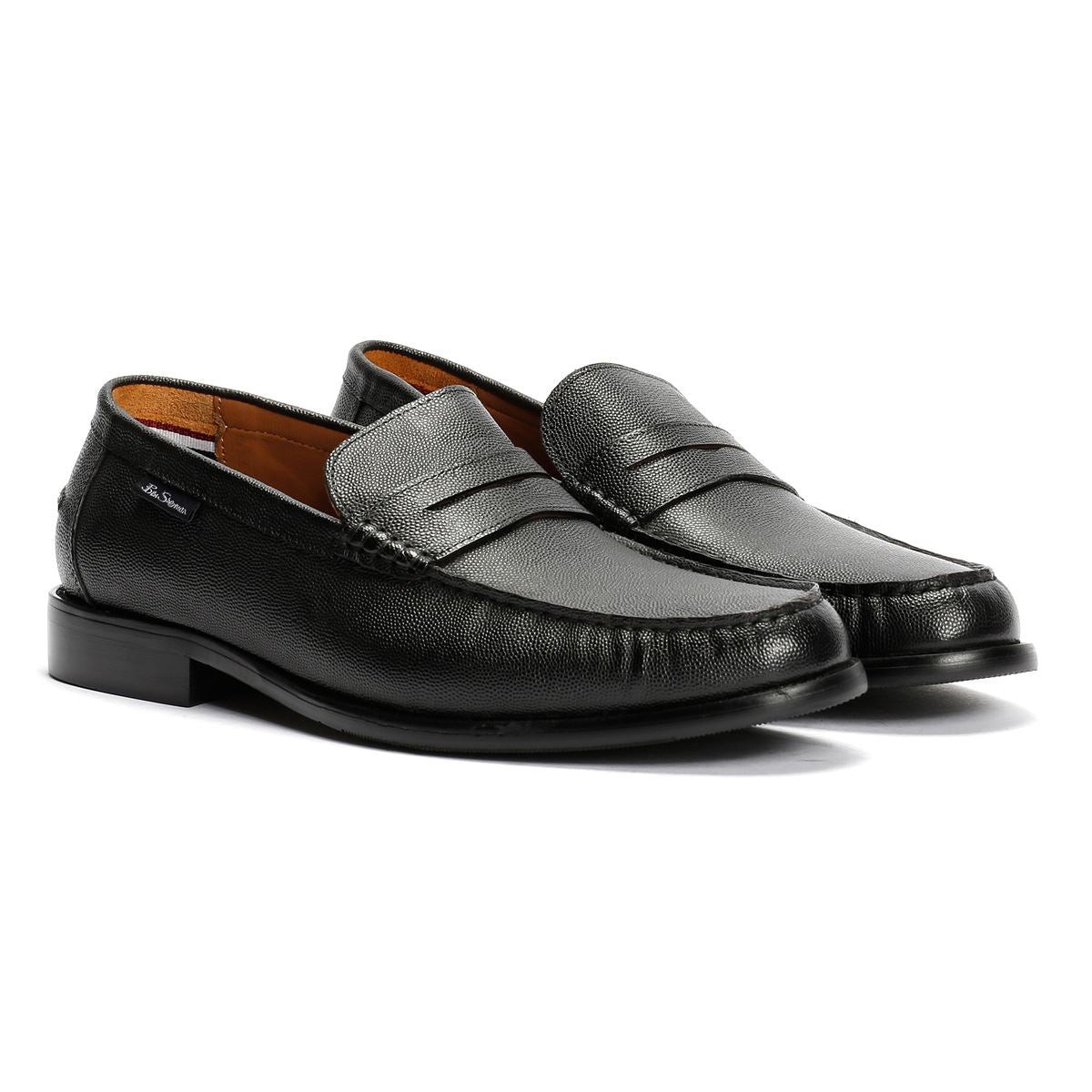 Black leather loafers with a textured finish, featuring a classic penny strap design and a low heel, ideal for formal or casual wear.