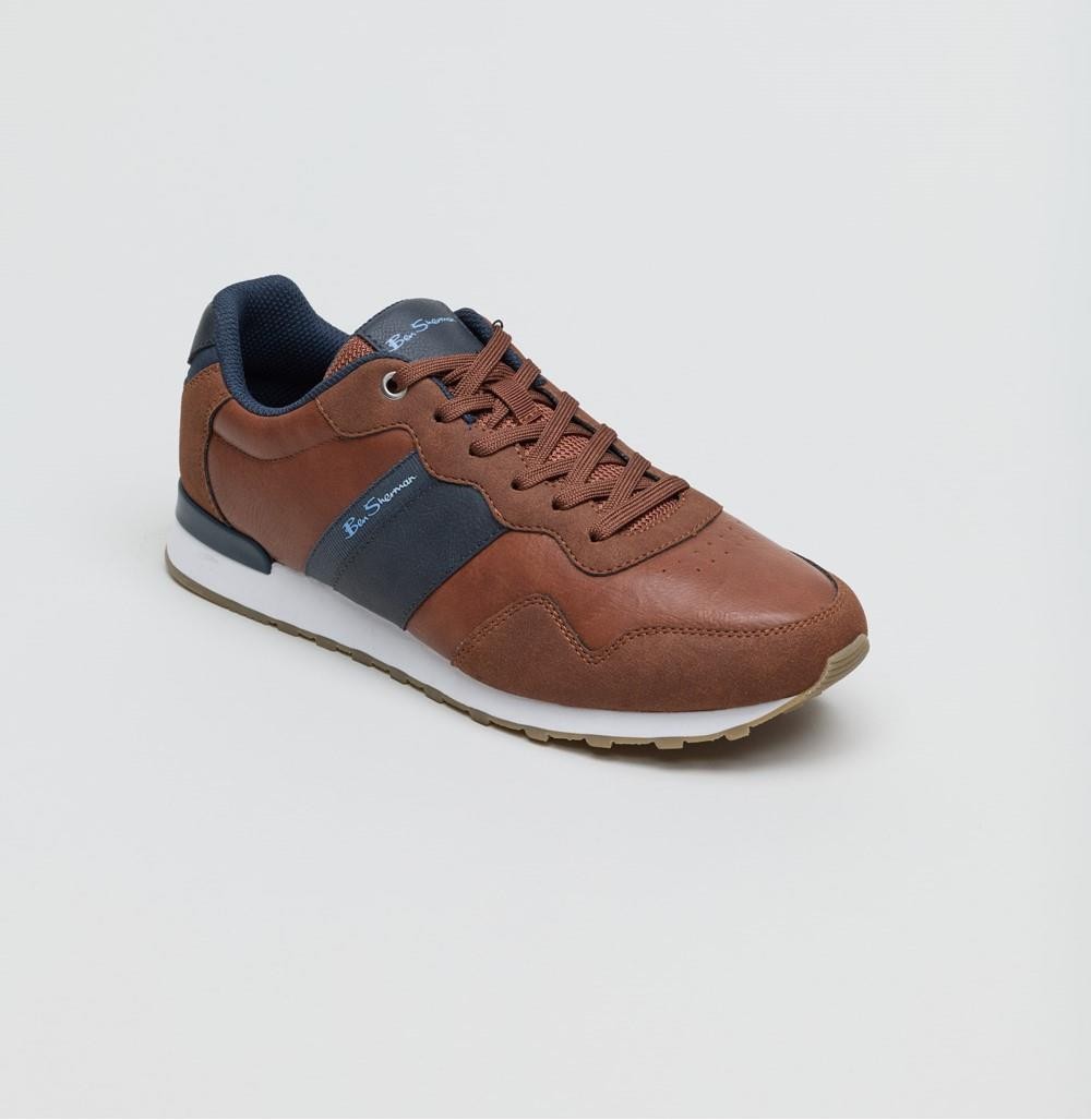 Tan and navy retro trainers featuring a leather upper, textured detailing, lace-up front, and a white rubber sole for a stylish, sporty look.