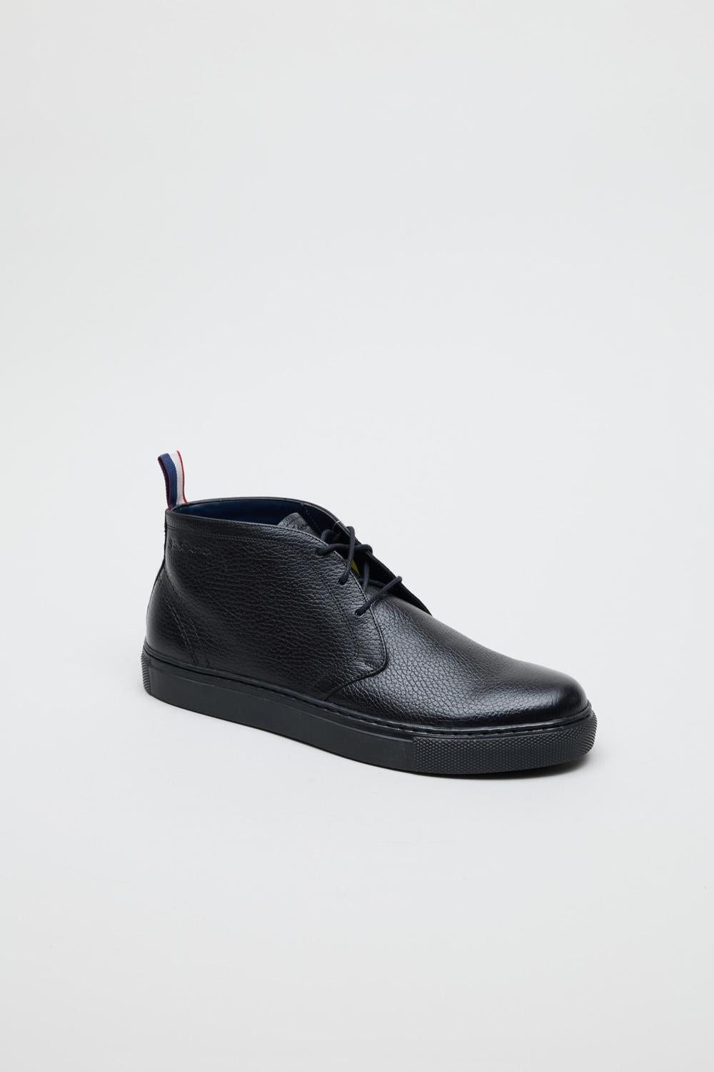 Black milled leather parka boots with a sleek design, featuring a rounded toe, lace-up front, and a contrasting red, white, and blue tab at the heel.