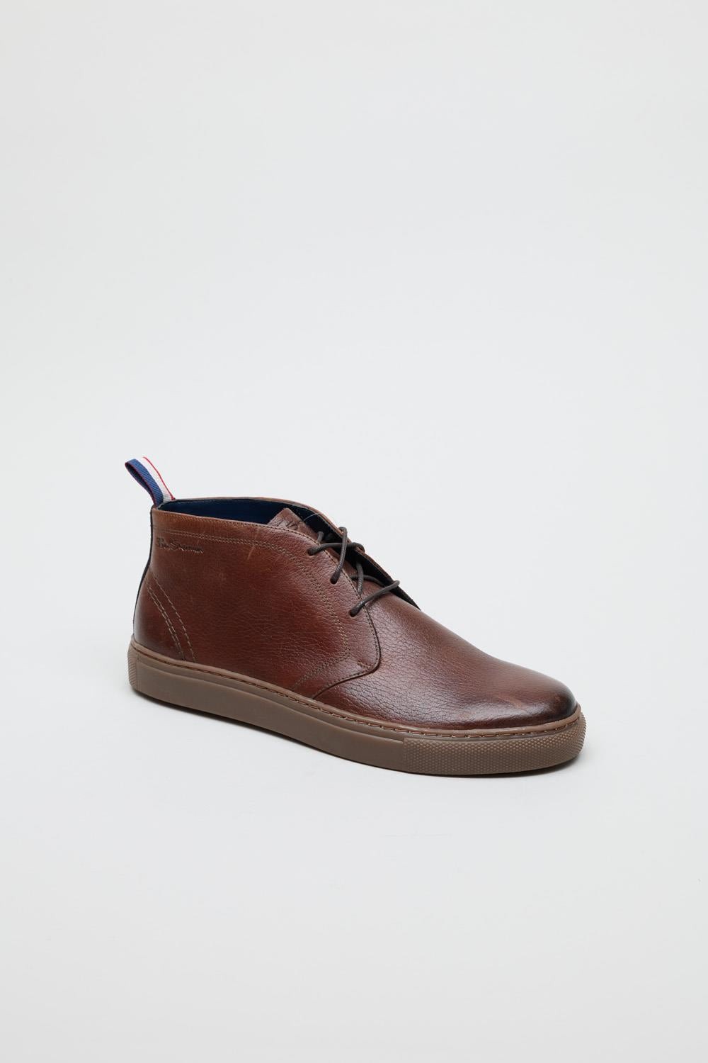 Brown milled leather parka boots featuring a sleek design, round toe, lace-up closure, and a contrasting blue interior with a red and white striped heel tab.