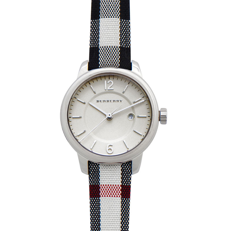 Classic round women's watch by Burberry featuring a silver-tone case, white textured dial, black and white check fabric strap, and minimalist hour markers.