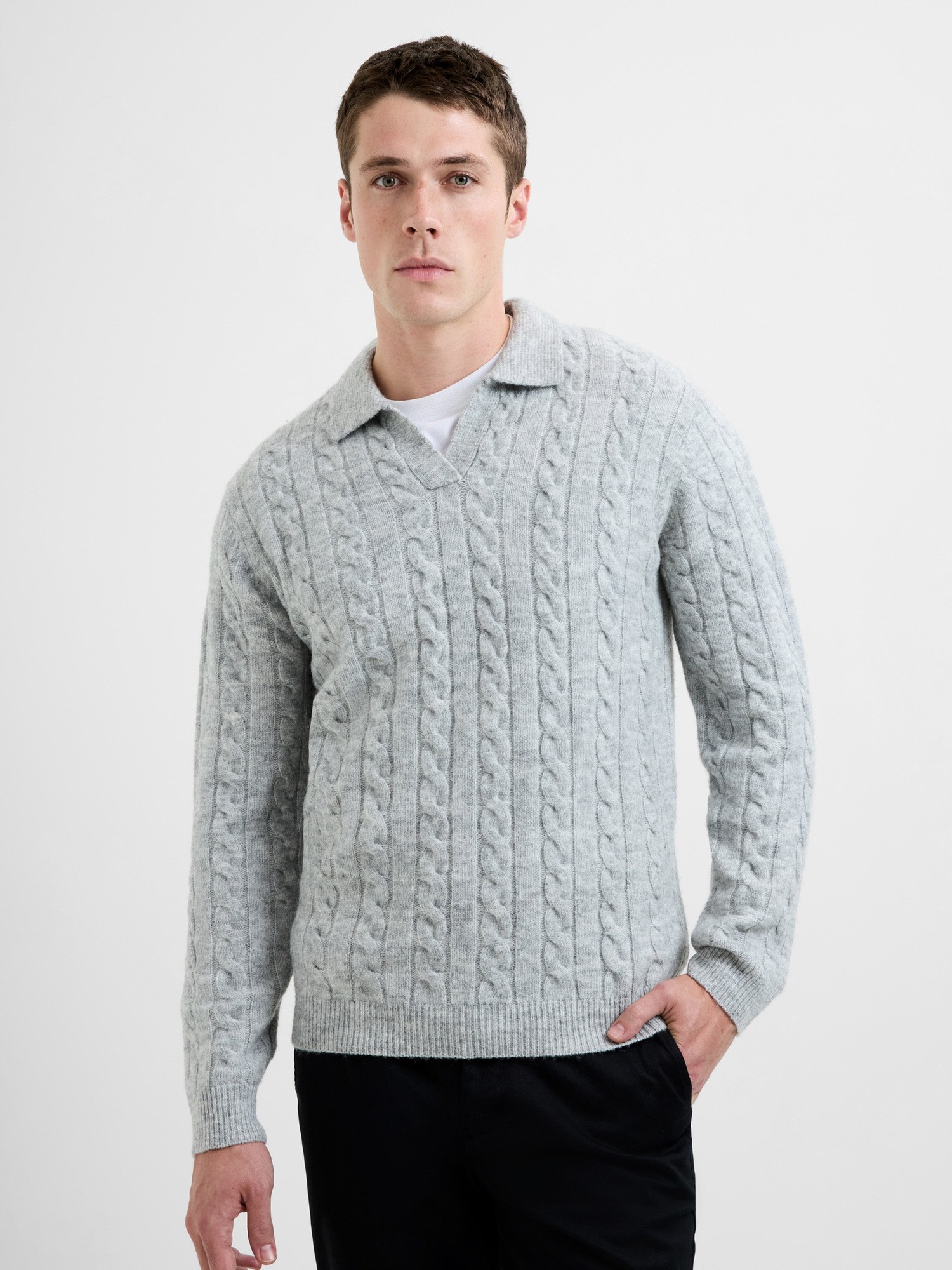 Light grey cable knit polo jumper with a trophy neck, featuring a textured pattern and long sleeves, styled with a relaxed fit.
