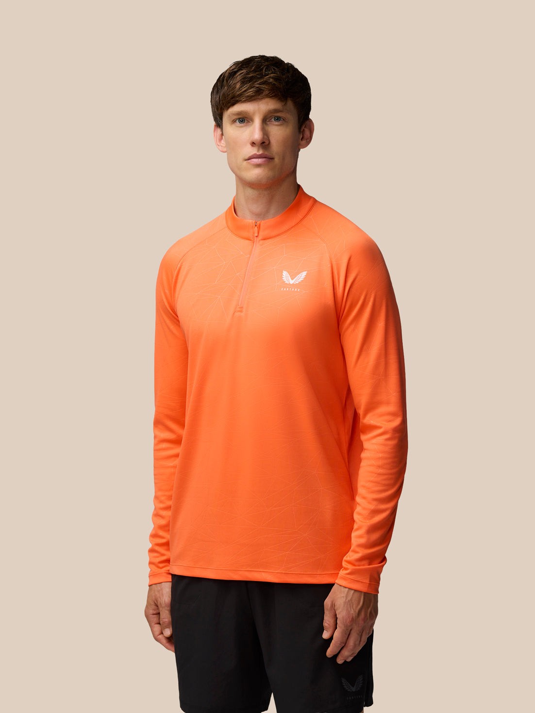 Bright orange polyester 1/4 zip training top for men, featuring a subtle geometric pattern and a small white logo on the chest, ideal for activewear.