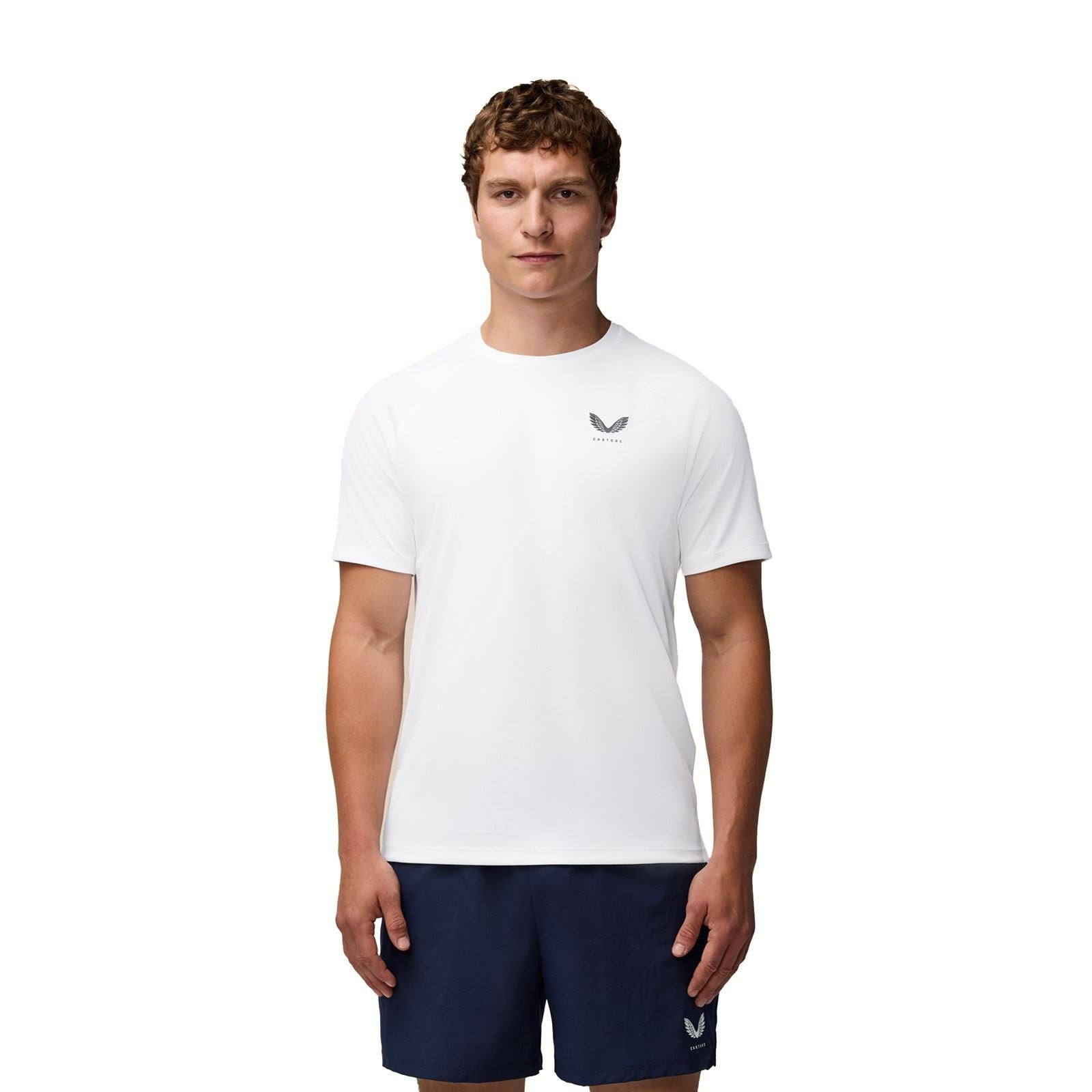 White polyester training t-shirt for men by Castore, featuring a crew neck, short sleeves, and a subtle logo on the chest, paired with navy shorts.
