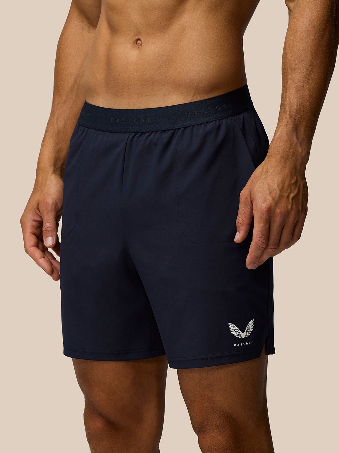 Blue polyester elastic shorts for men, featuring a comfortable waistband, side pockets, and a subtle Castore logo with a wing design on the left leg.