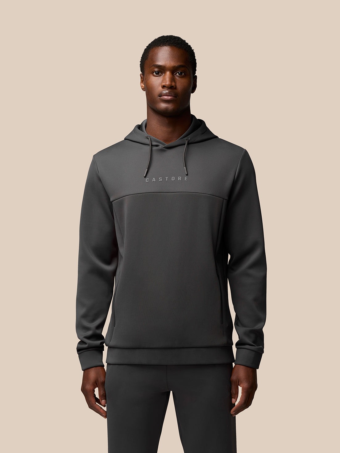Grey polyester hooded sweatshirt featuring a minimalist design with a front logo, adjustable drawstring hood, and a sleek, athletic fit.