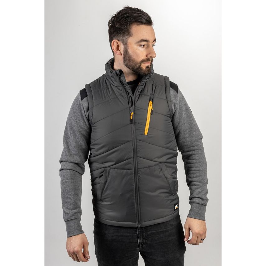 Dark shadow body warmer featuring a quilted design, zippered chest pocket with yellow accent, and a high collar, worn over a grey long-sleeve shirt.