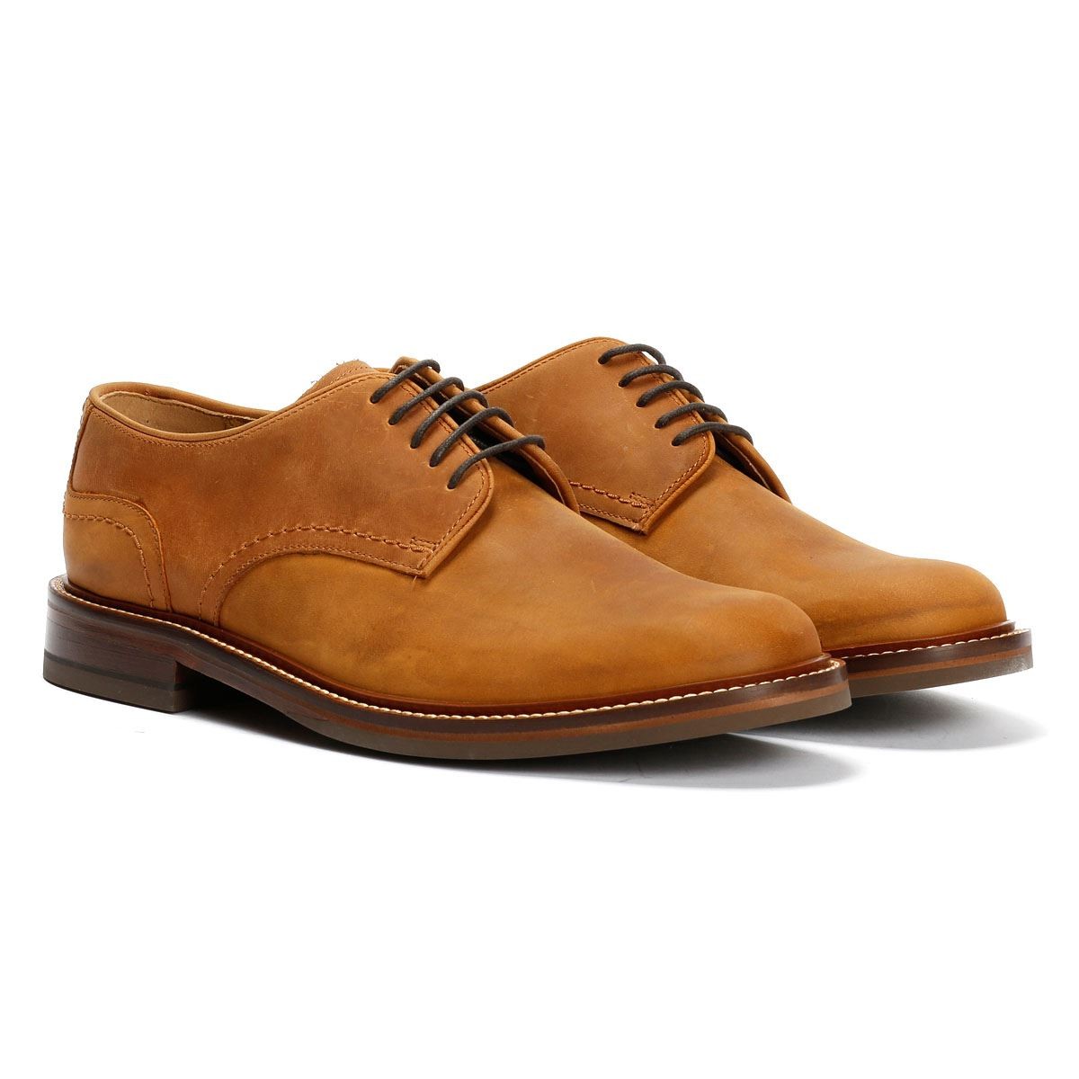 Tan oiled leather Derby shoes featuring a smooth finish, rounded toe, and classic lace-up design, set on a sturdy brown sole with subtle stitching details.