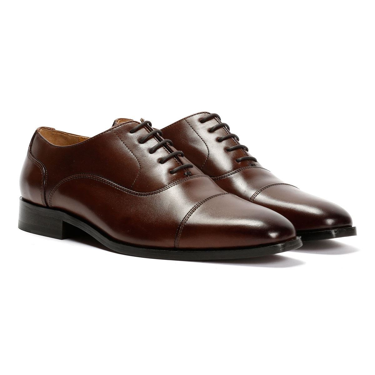 Chocolate brown leather Oxford shoes with a toe cap design, featuring a sleek silhouette, laces, and a low stacked heel.