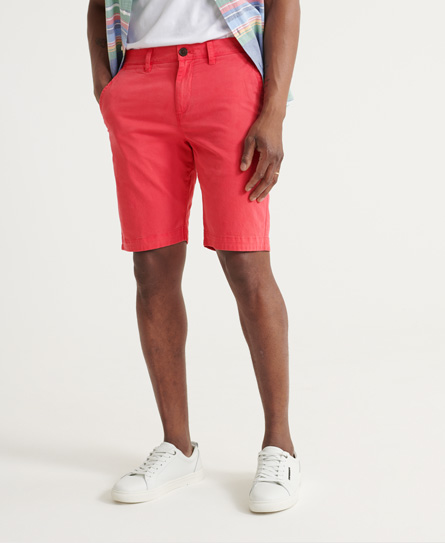 Red chino shorts by Superdry, featuring a classic fit, side pockets, and a button closure, paired with a light-colored top and white sneakers.