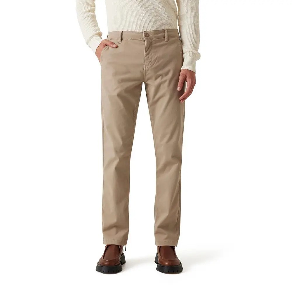 Beige chino trousers by Guess, featuring a slim fit, side pockets, and a button closure, paired with a cream sweater and brown shoes.
