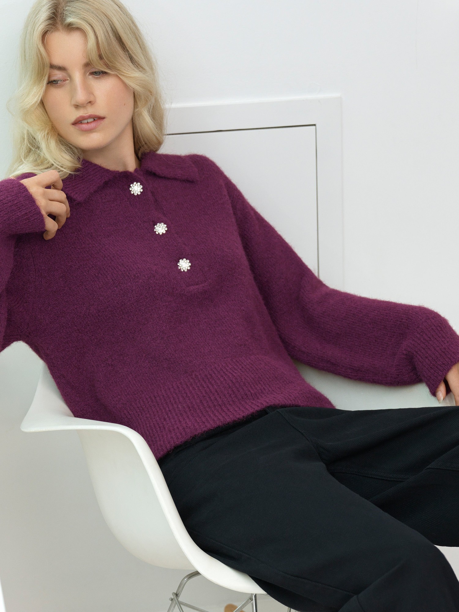 Purple knitted jumper featuring a polo collar and three diamante button details, styled with relaxed sleeves and paired with black trousers.