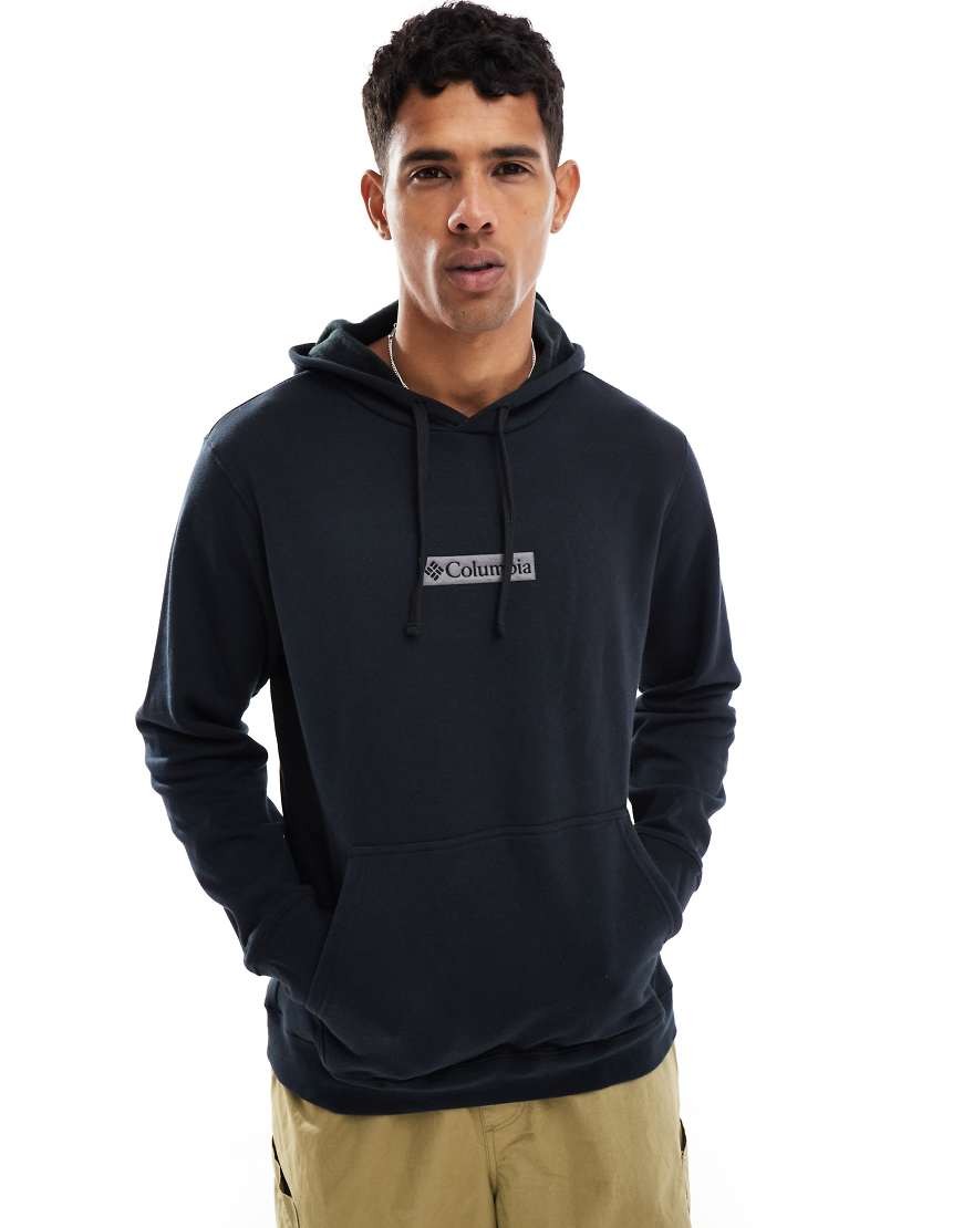 Black hooded sweatshirt made of cotton, featuring a front logo patch with "Columbia," and a relaxed fit with a kangaroo pocket.