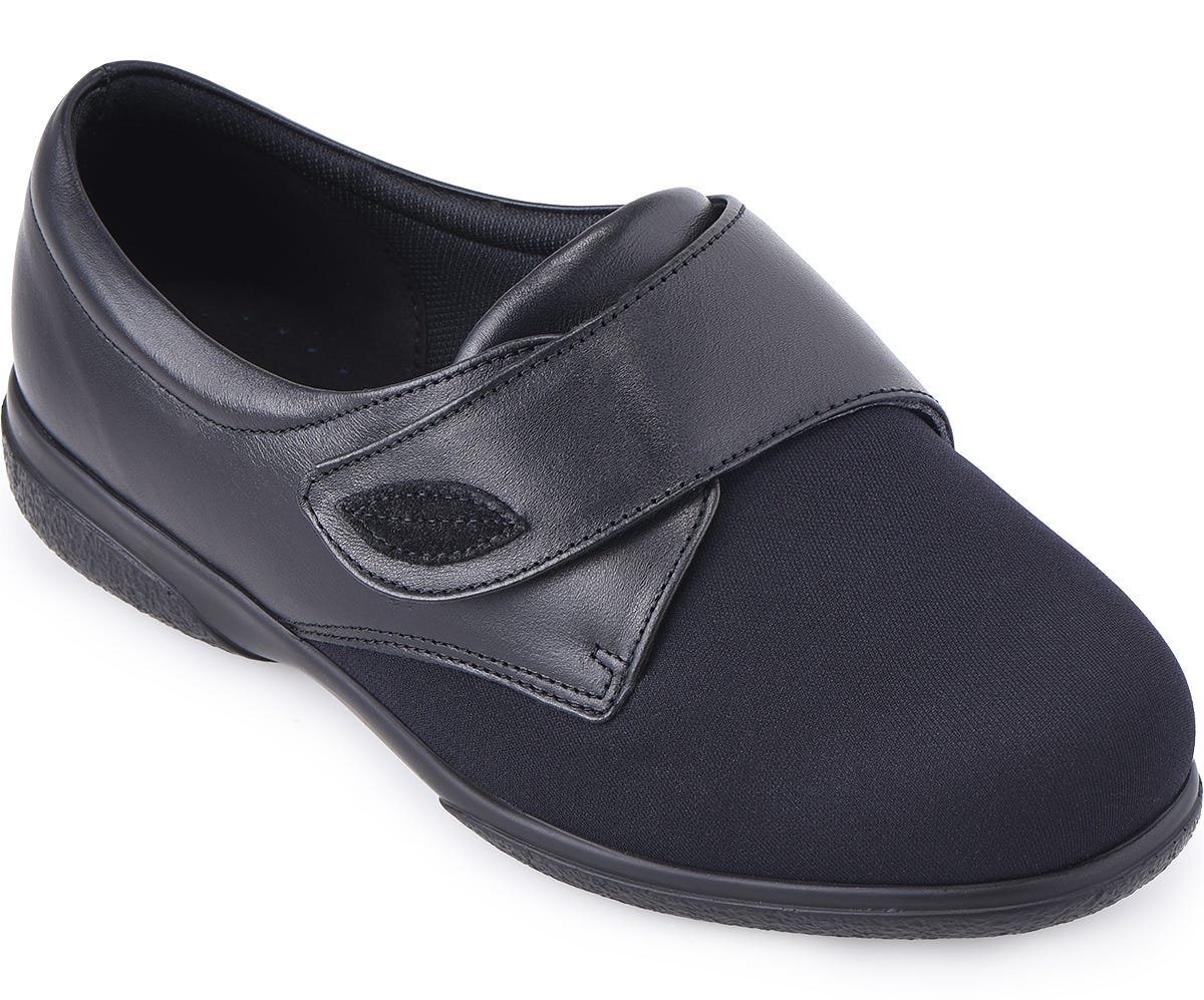 Black extra wide shoe featuring a soft fabric upper, adjustable Velcro strap, and cushioned insole, designed for comfort and support for swollen feet.