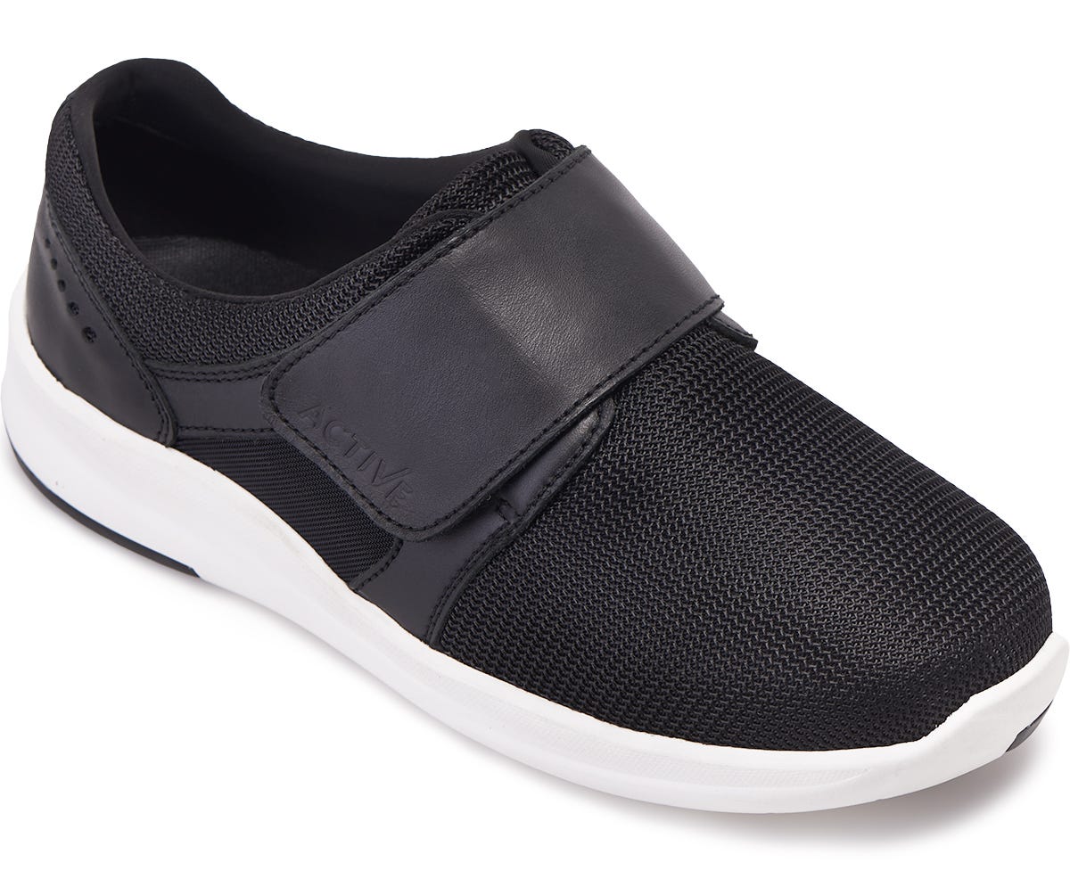 Black mesh slip-on shoe with a wide fit, featuring a Velcro strap across the top for easy adjustment and a white rubber sole for comfort and support.