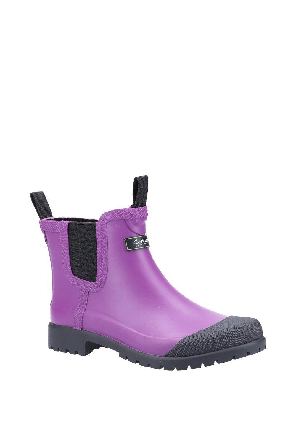 Purple waterproof ankle boot with a black elastic panel, sturdy rubber sole, and pull tabs for easy wear, designed for women's outdoor activities by Cotswold.