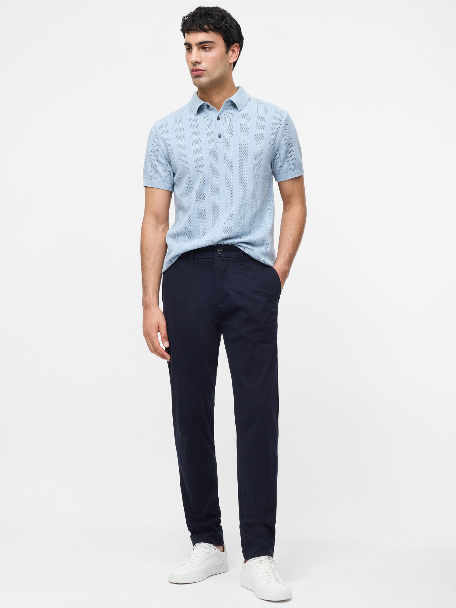 Navy cotton stretch chinos with a regular fit, featuring a classic design, paired with a light blue polo shirt and white sneakers.