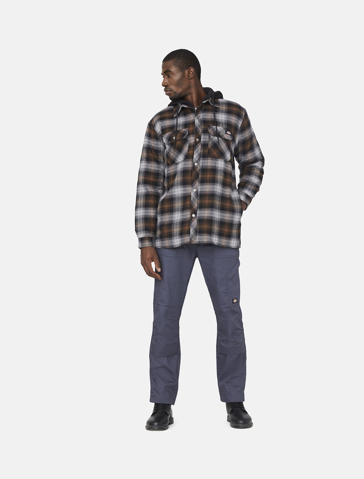 Men's grey outdoor trousers made from durable polyester, featuring a flexible fit, multiple pockets, and a rugged design, paired with a plaid flannel shirt and black boots.