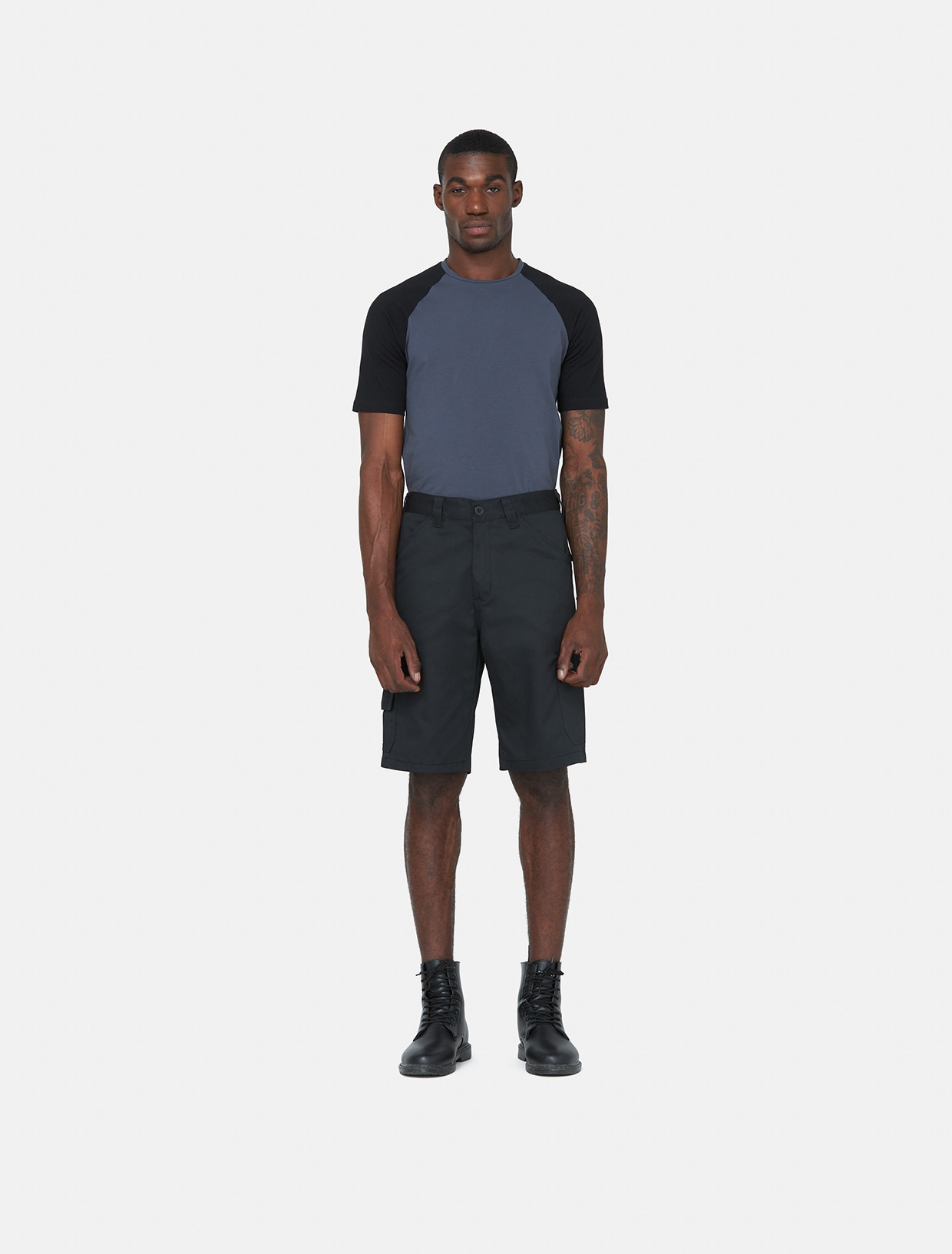 Black knee-length shorts made of polyester, featuring a classic design, front pockets, and a relaxed fit, paired with a gray and black short-sleeve shirt.