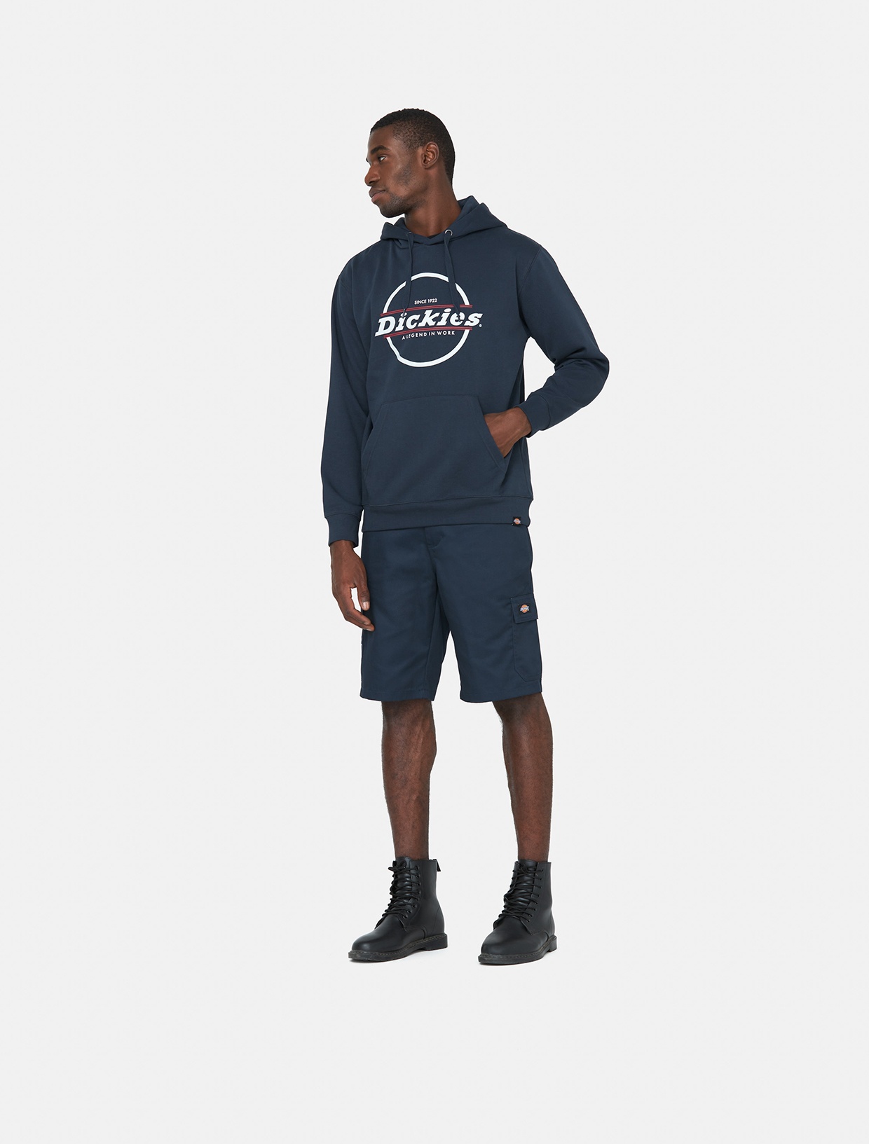Blue knee-length shorts made of polyester, featuring side pockets and a relaxed fit, paired with a navy hoodie and black boots.