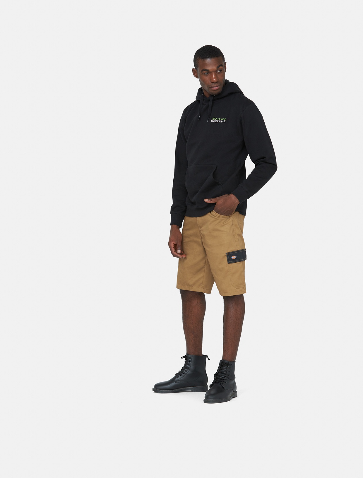 Brown knee-length shorts made of polyester, featuring side pockets and a cargo pocket, paired with a black hoodie and black boots.