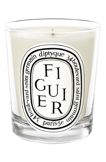Classic Diptyque candle in a clear glass container, featuring a white wax interior and a prominent black and white label with "Figuier" text and an oval design.