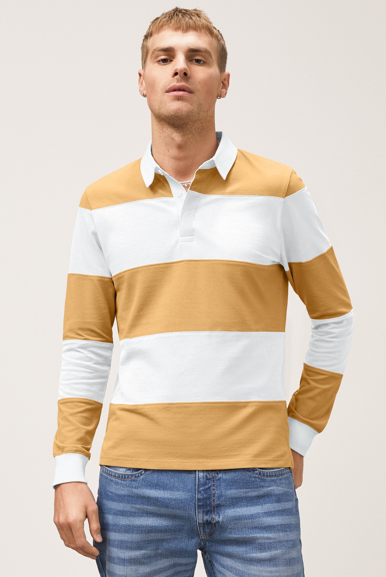Yellow and white color block long-sleeve polo shirt with a woven collar, featuring a relaxed fit, worn by a model paired with blue jeans.