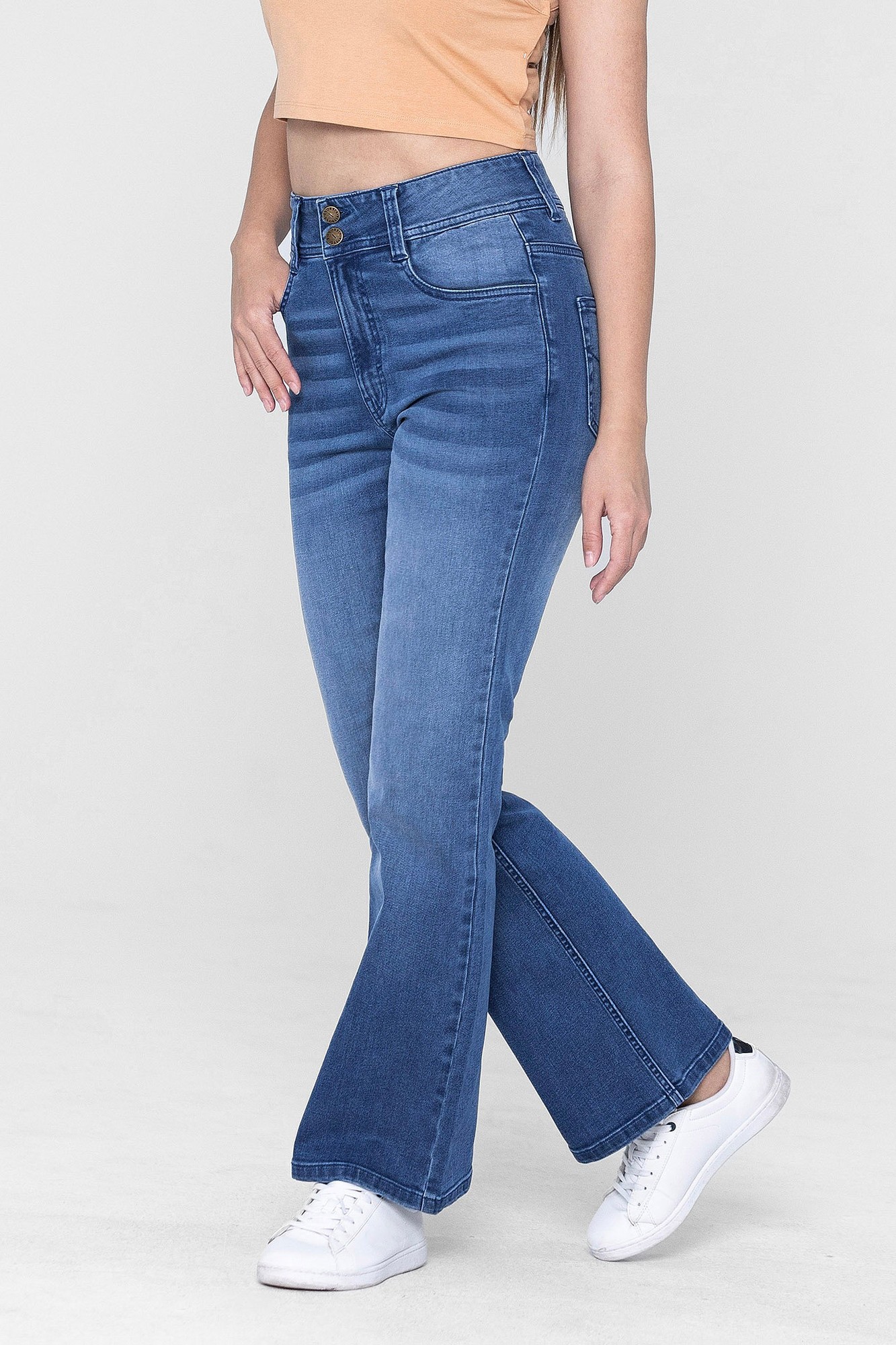 Mid blue slim shape boot cut jeans with a high waist, featuring front pockets and a button closure, styled with a light orange top and white sneakers.