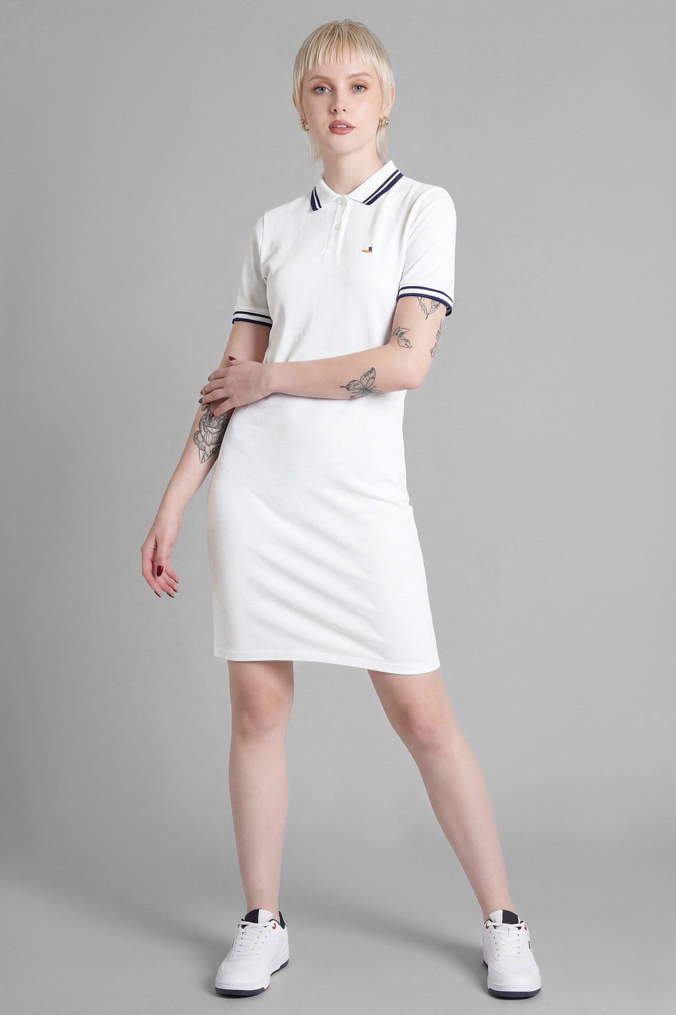 White longline polo dress by Enorsia, UK size 8, featuring a classic collar, navy striped trim on sleeves, and a fitted silhouette, styled with white sneakers.