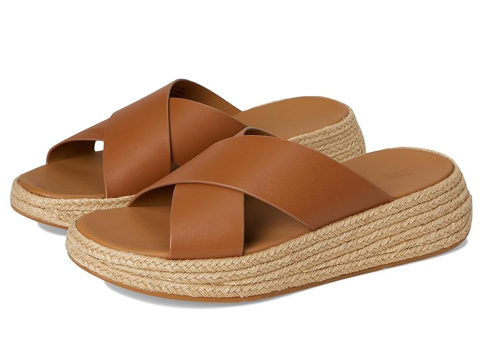Deep tan leather clogs with cross-strap design, featuring a woven jute platform sole for added height and comfort.