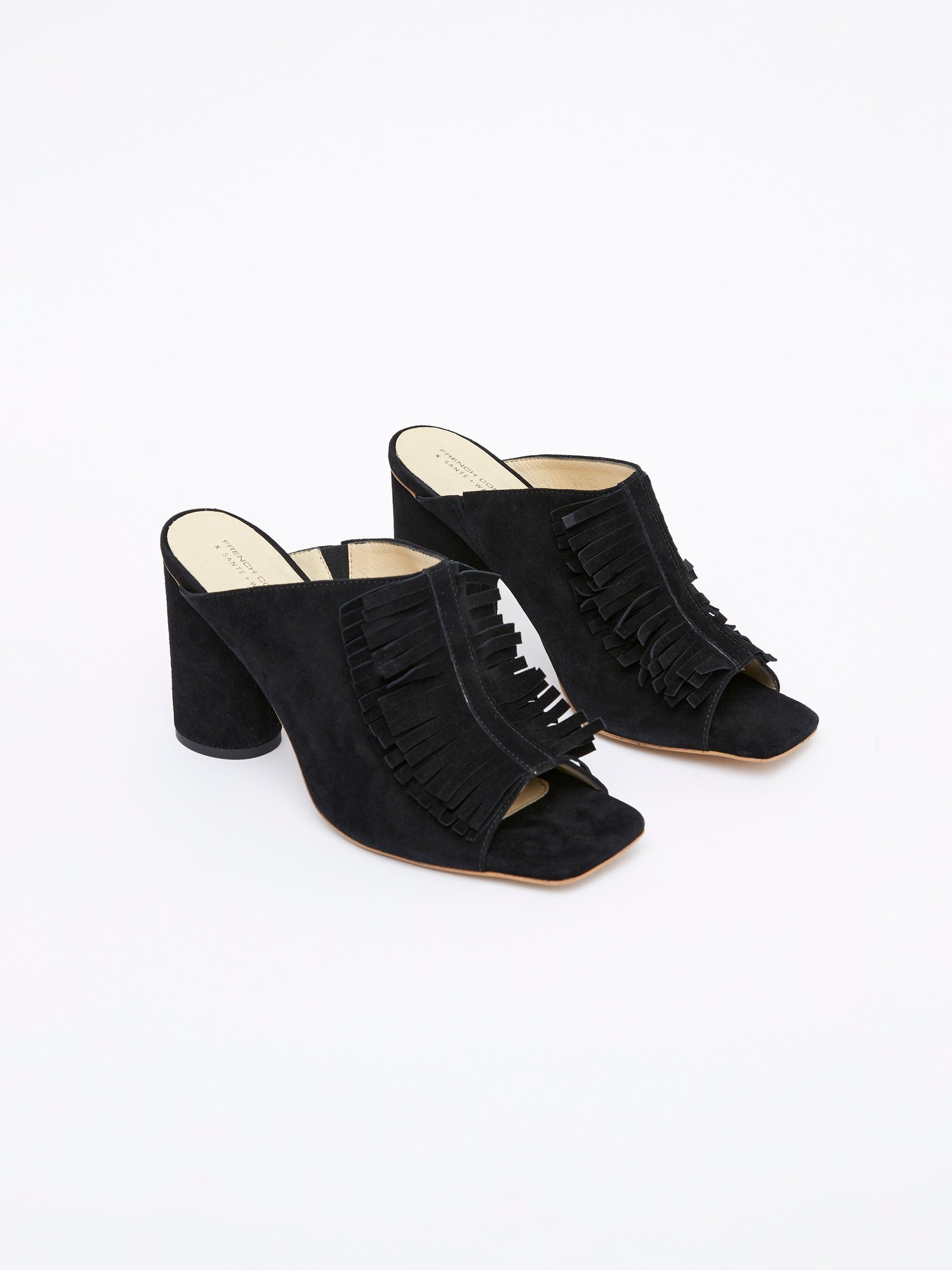 Black suede mules featuring a fringed design on the front and a chunky heel, offering a stylish and modern look for any outfit.