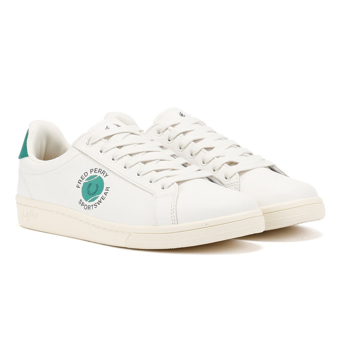 White leather trainers with green accents, featuring a round toe, lace-up front, and Fred Perry logo on the side, set on a textured rubber sole.