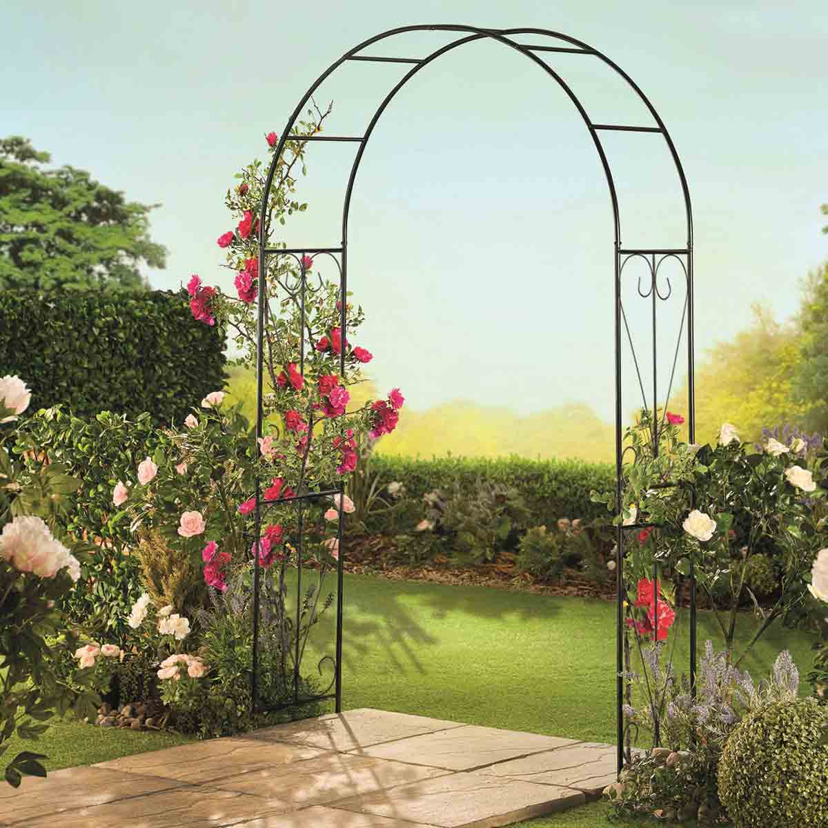 Black metal garden arch with a swirl design, standing 2.2m tall, adorned with vibrant pink roses, set against a lush green garden backdrop.